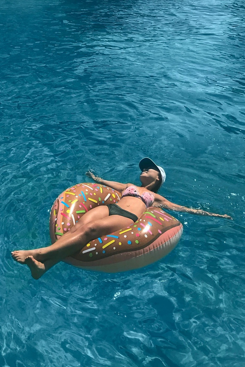 Woman floating on rubber ring on blue water